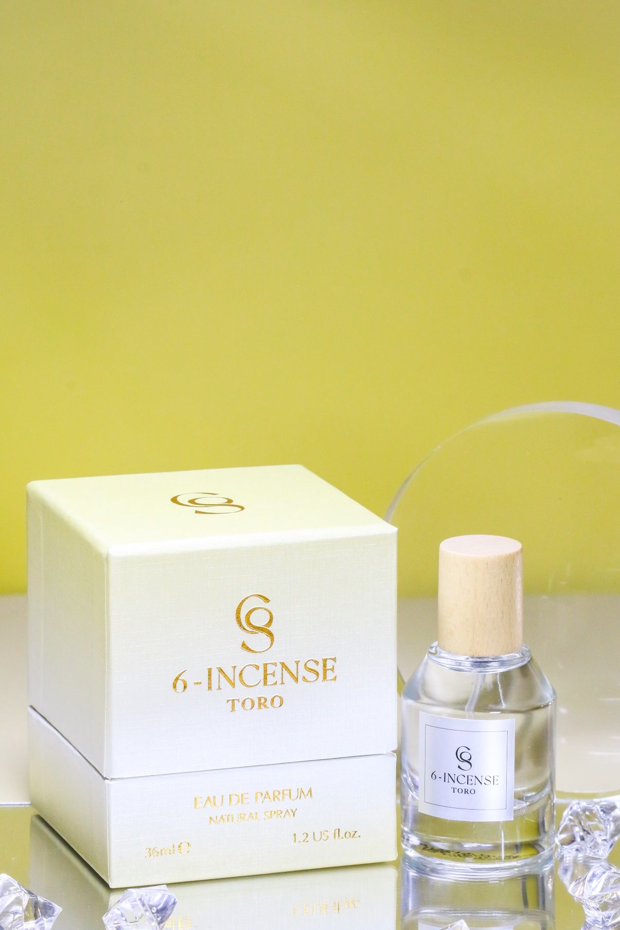 A small white box with a small bottle of perfume\n\nDescription automatically generated